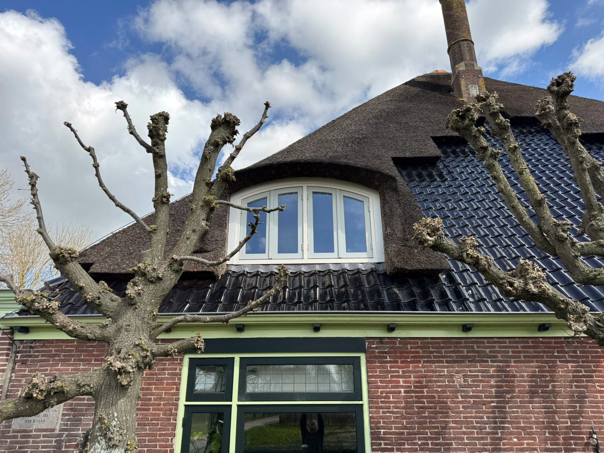 Maatwerk halfrond kozijn in rieten dak bij B&B La Normande in Westwoud
