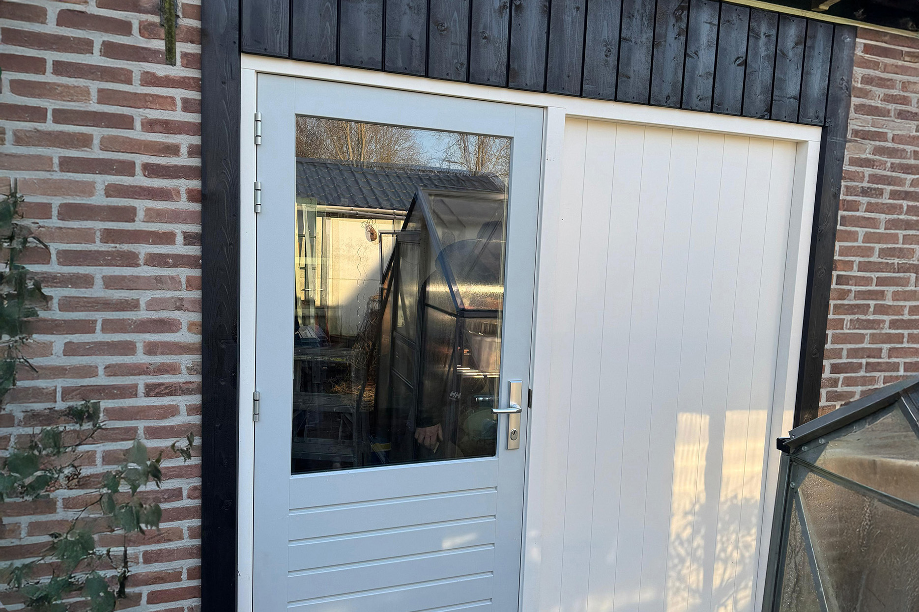 Schuur vernieuwd met kunststof kozijn en houten schuurdeur